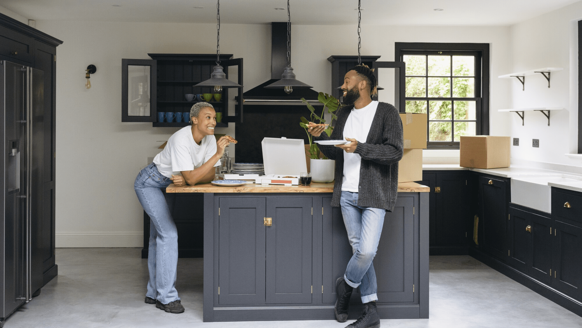 Two people laughing in stylish kitchen
